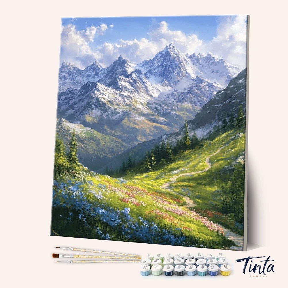 Angled display of the Alpine Meadow Path paint by numbers kit showing mountain meadow canvas with brushes and paints by Tinta Canvas