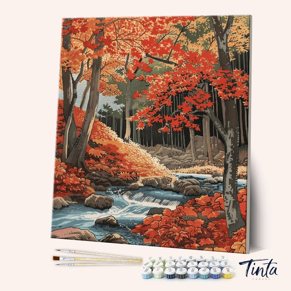 Autumn Whisper Creek paint by numbers kit angled display showing autumn forest canvas with paint pots and brushes by Tinta Canvas