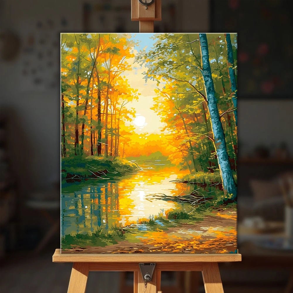 Autumnal Reflections paint by numbers kit on easel displaying warm forest scene and sunlit water by Tinta Canvas