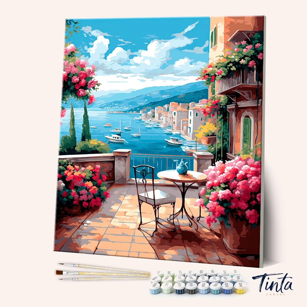 Blue Sky Harbor paint by numbers kit angled view showing terrace with flowers overlooking boats and coastal town