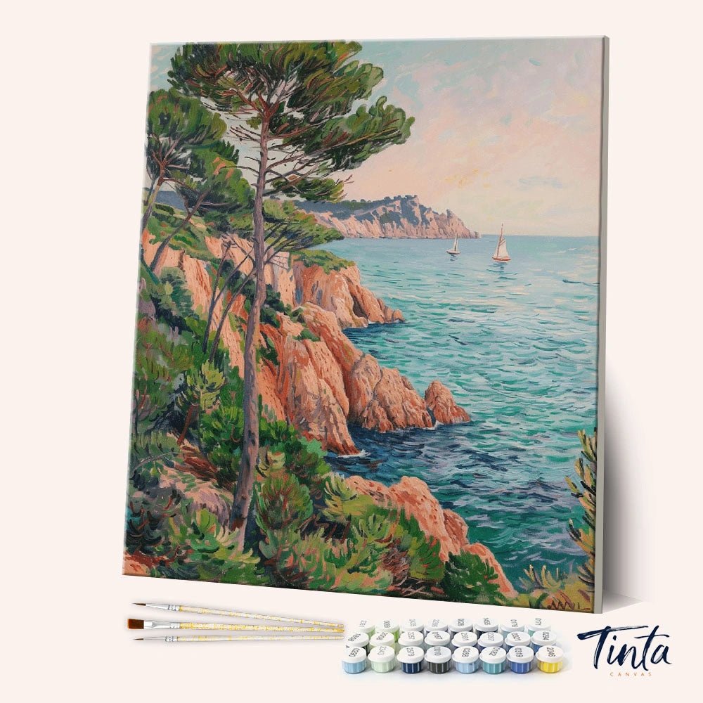 Angled display of the Coastal Pines paint by numbers kit showing seaside cliff canvas with brushes and paint pots by Tinta Canvas