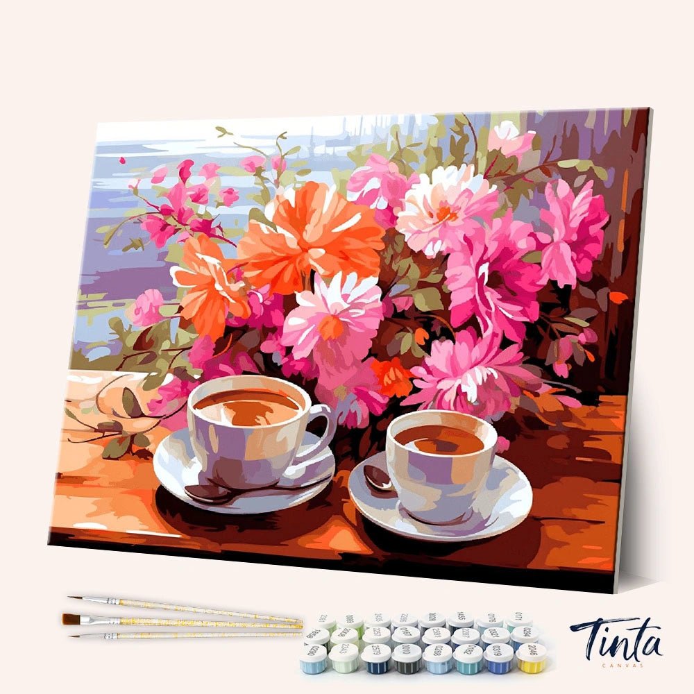 Angled display of Coffee in Bloom paint by numbers kit featuring two coffee cups on a table beside vibrant blooming flowers by Tinta Canvas