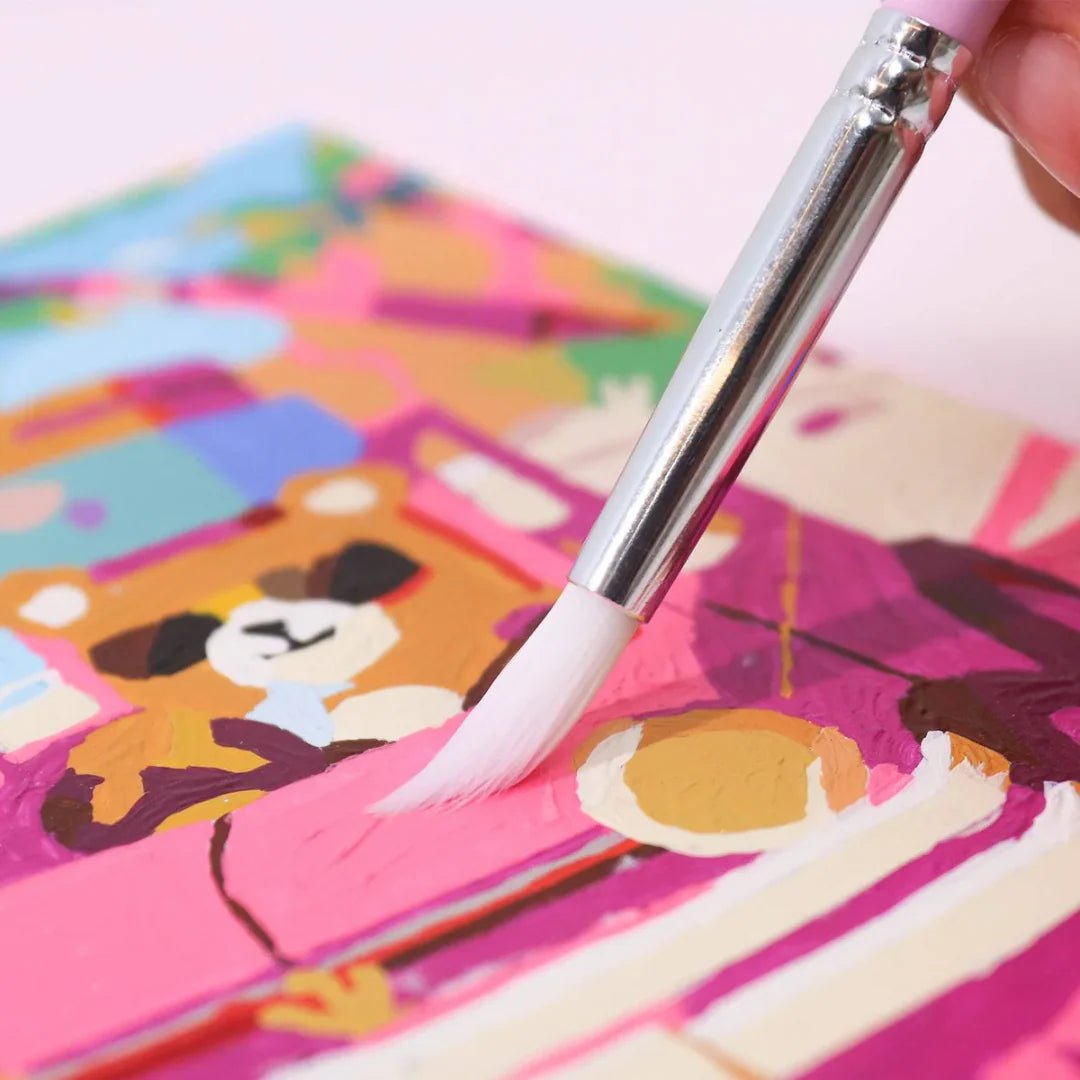 Colorful children's book with a teddy bear illustration and a brush applying paint.