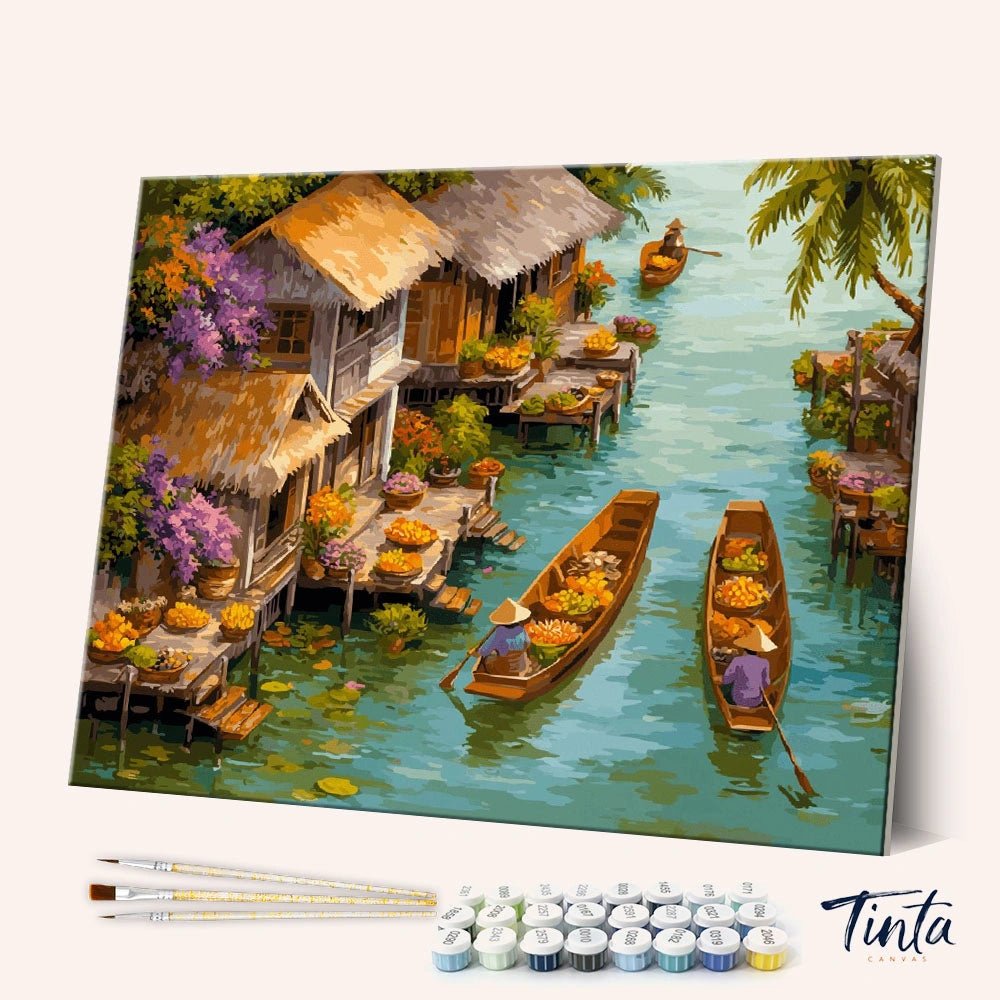 Angled display of the Floating Market paint by numbers kit showing colorful canal market canvas with brushes and paint pots by Tinta Canvas