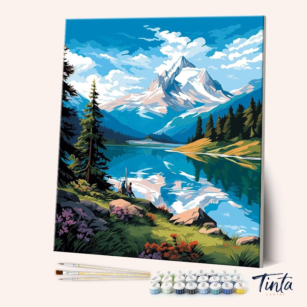Angled display of the Glacier Mirror Lake paint by numbers kit showing alpine lake canvas with brushes and paint pots by Tinta Canvas