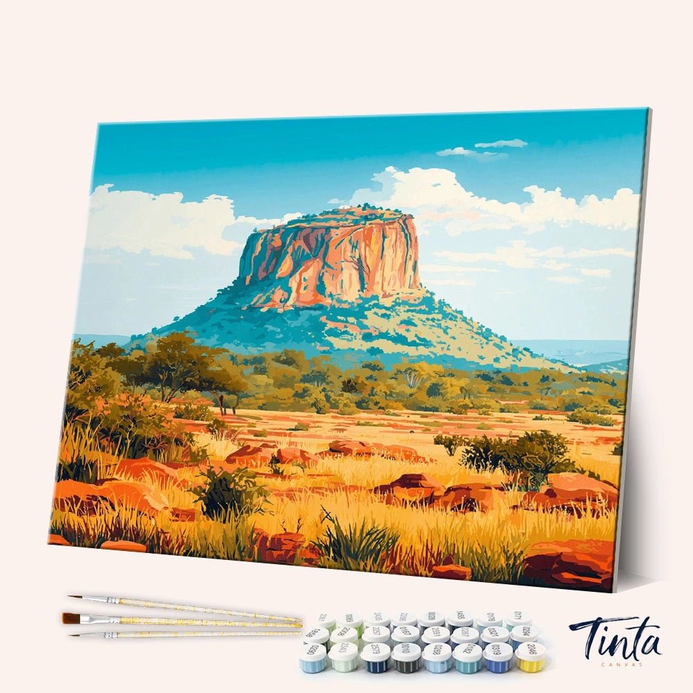 Angled display of Kruger National Park paint by numbers kit showing rocky mesa rising above golden savanna landscape by Tinta Canvas