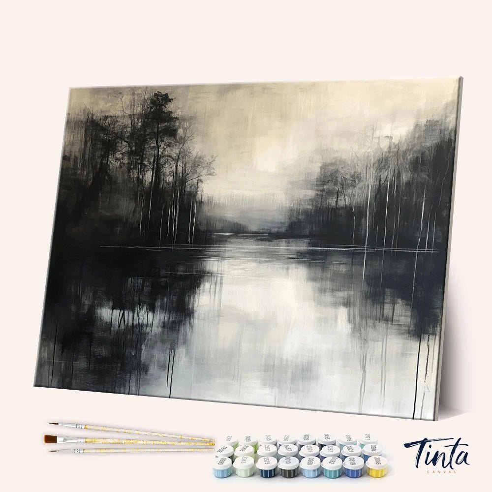 Angled display of the Misty Reflection paint by numbers kit showing misty forest lake canvas with brushes and paint pots by Tinta Canvas