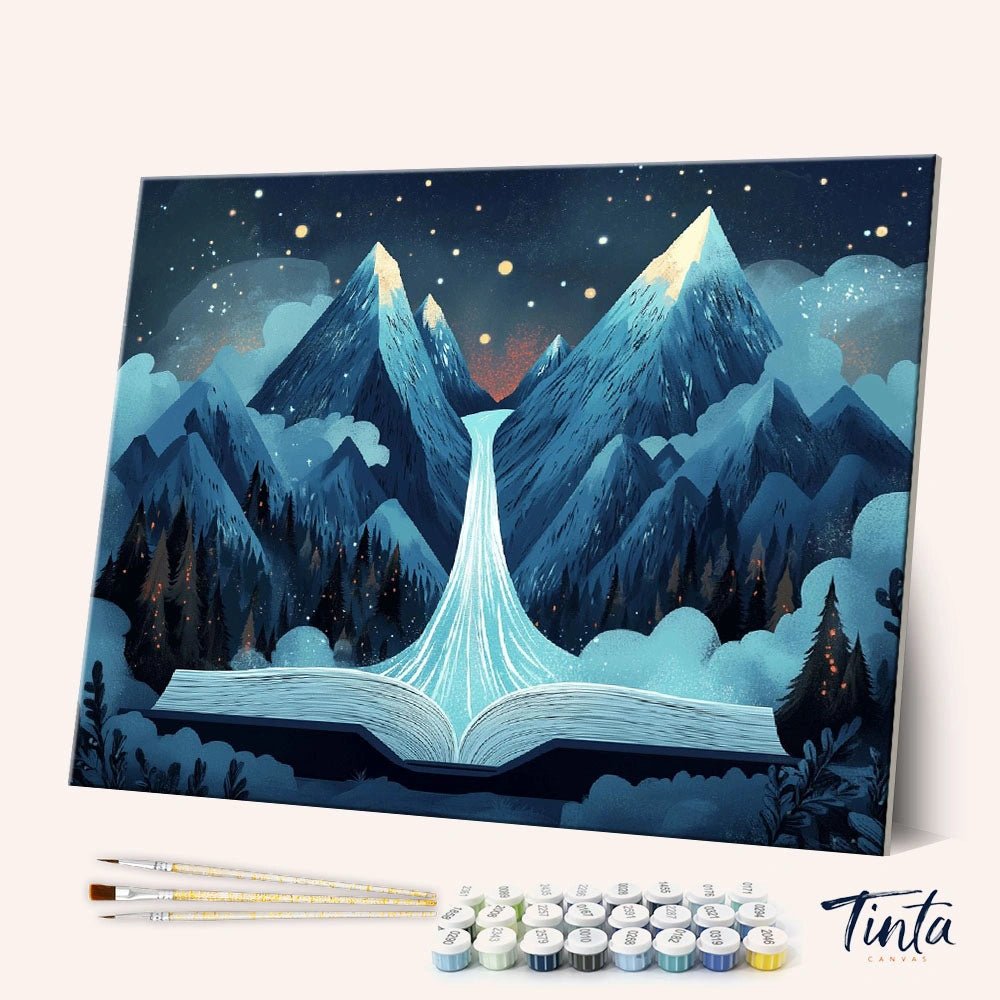 Angled display of the Pages of Wonder paint by numbers kit showing a magical book opening into glowing mountains by Tinta Canvas