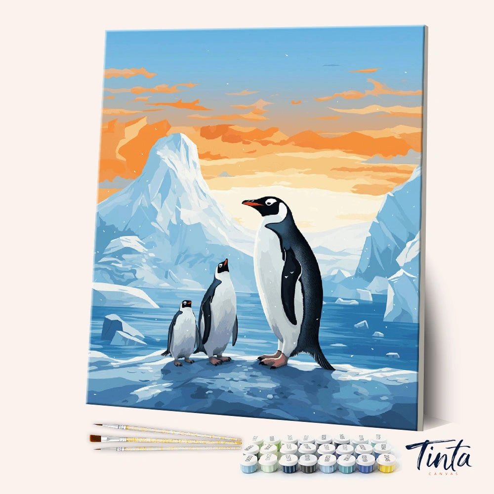 Angled display of the Penguin Family paint by numbers kit showing penguins standing on icy ground with snowy mountains behind by Tinta Canvas