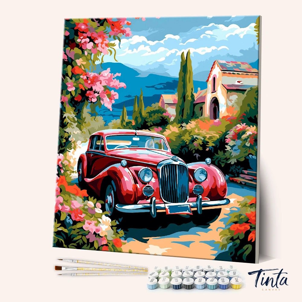 Angled view of Riviera Rose Drive paint by numbers kit featuring red vintage car on scenic coastal road by Tinta Canvas