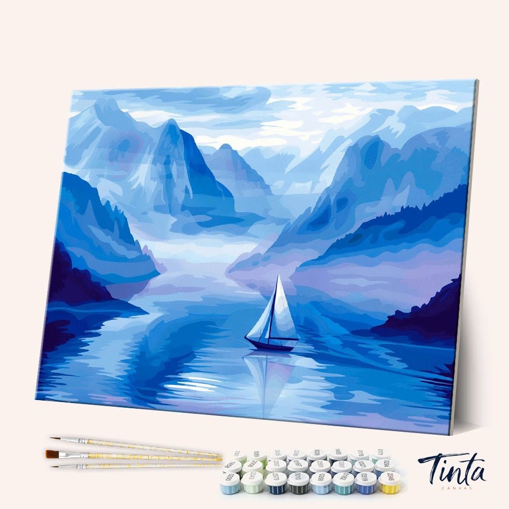 Angled display of the Silent Blue Passage paint by numbers kit showing serene mountain lake canvas with brushes and paints by Tinta Canvas