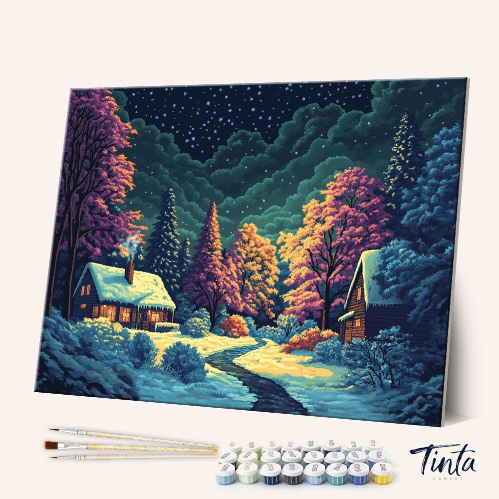 Winter Night Cabin paint by numbers kit shown in angled view with snowy cabins and glowing lights at night