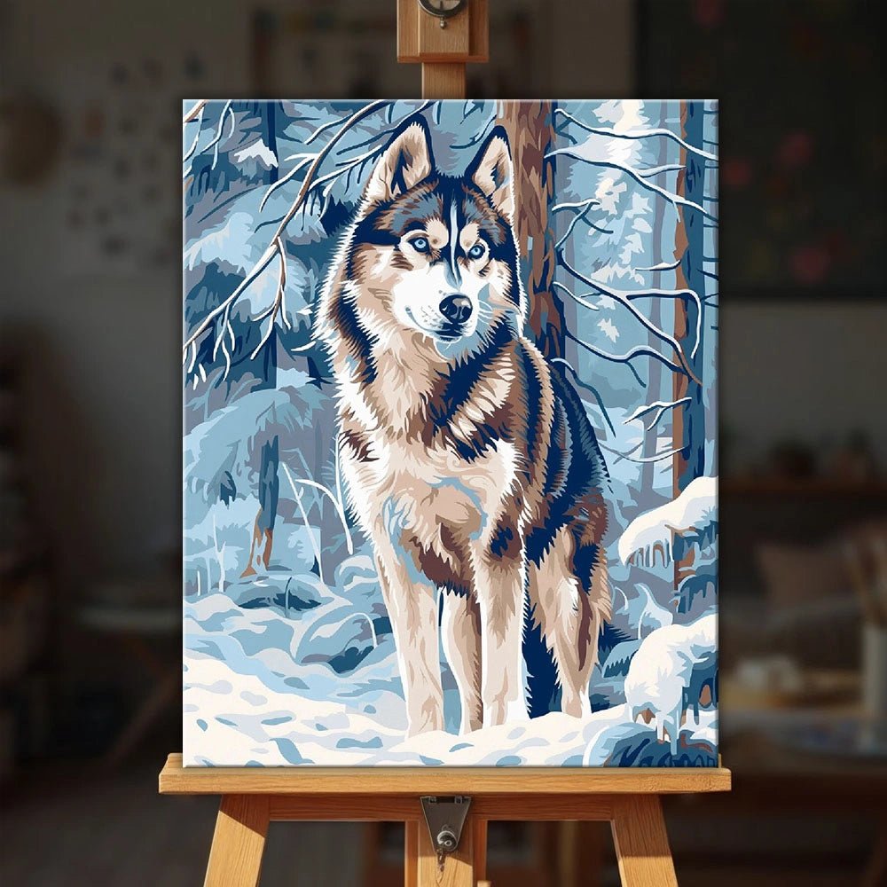 Winter Sentinel Wolf paint by numbers kit displayed on easel in cozy interior setting by Tinta Canvas