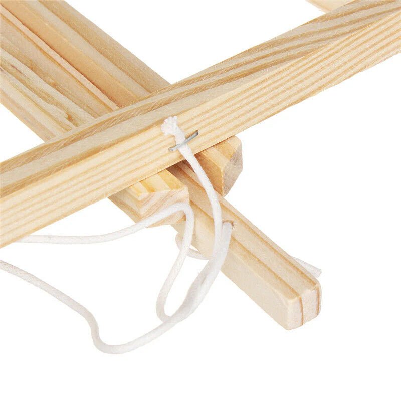 Close-up of wooden sticks with a white string tied between them on a white background