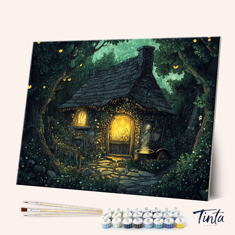 Angled display of the Woodland Haven paint by numbers kit showing a cozy glowing cottage in a magical forest by Tinta Canvas